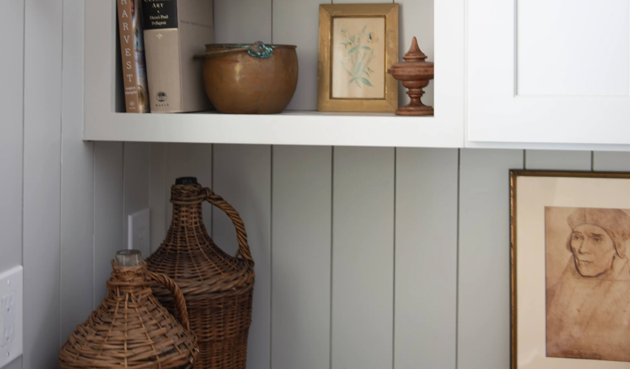 Wicker baskets and decor displayed on a white shelf.