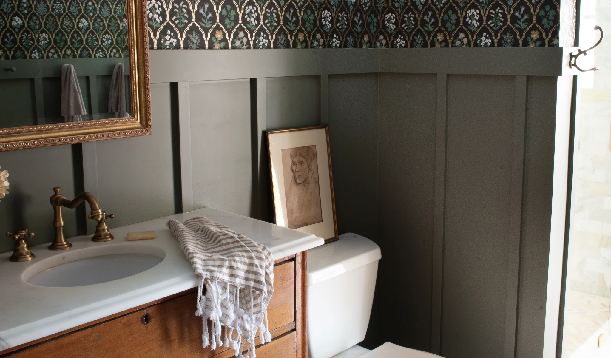 A bathroom with a toilet and a new mirror after a home improvement project.