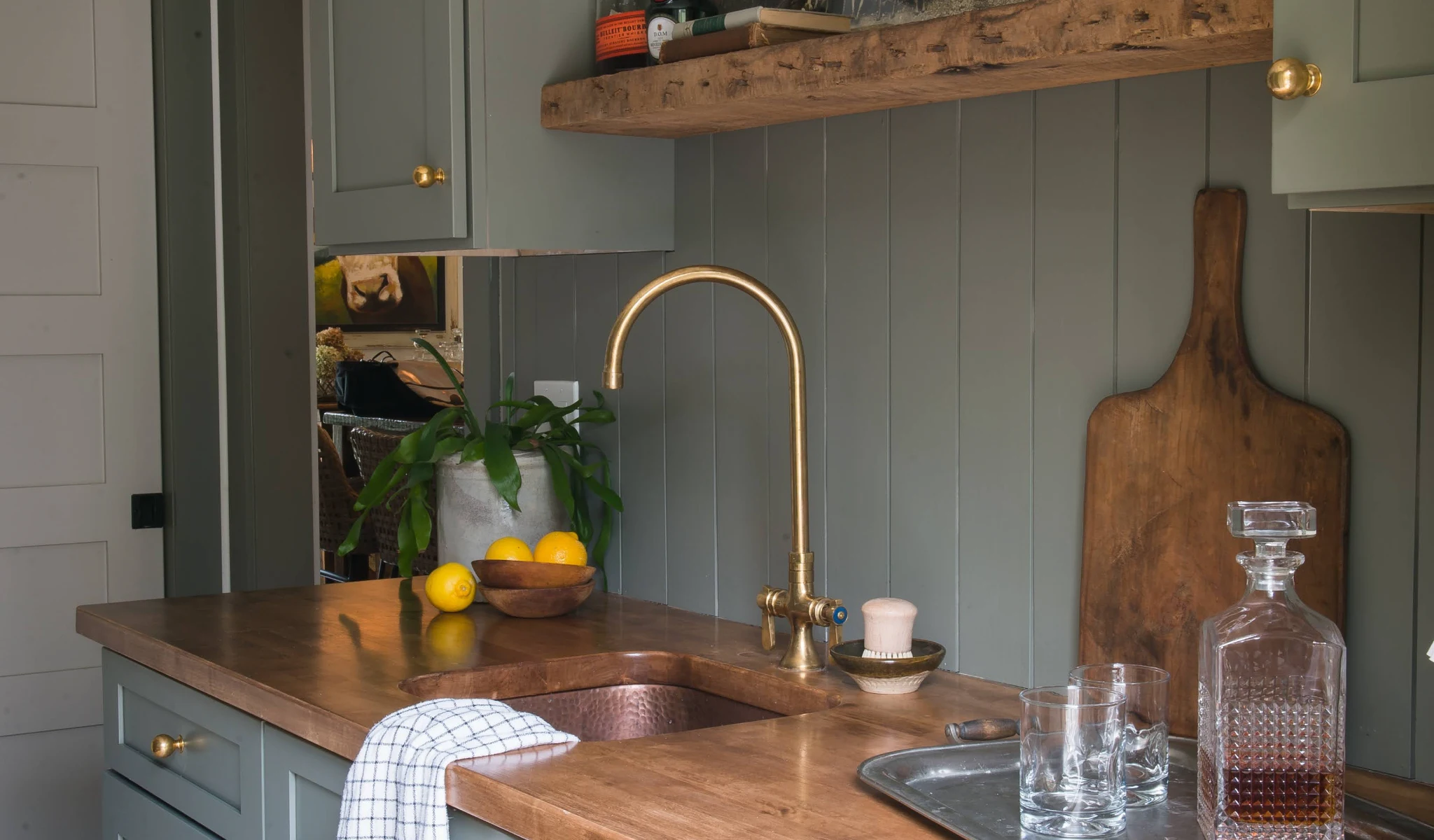 A kitchen with a wooden counter top and sink, the results of a home renovation.