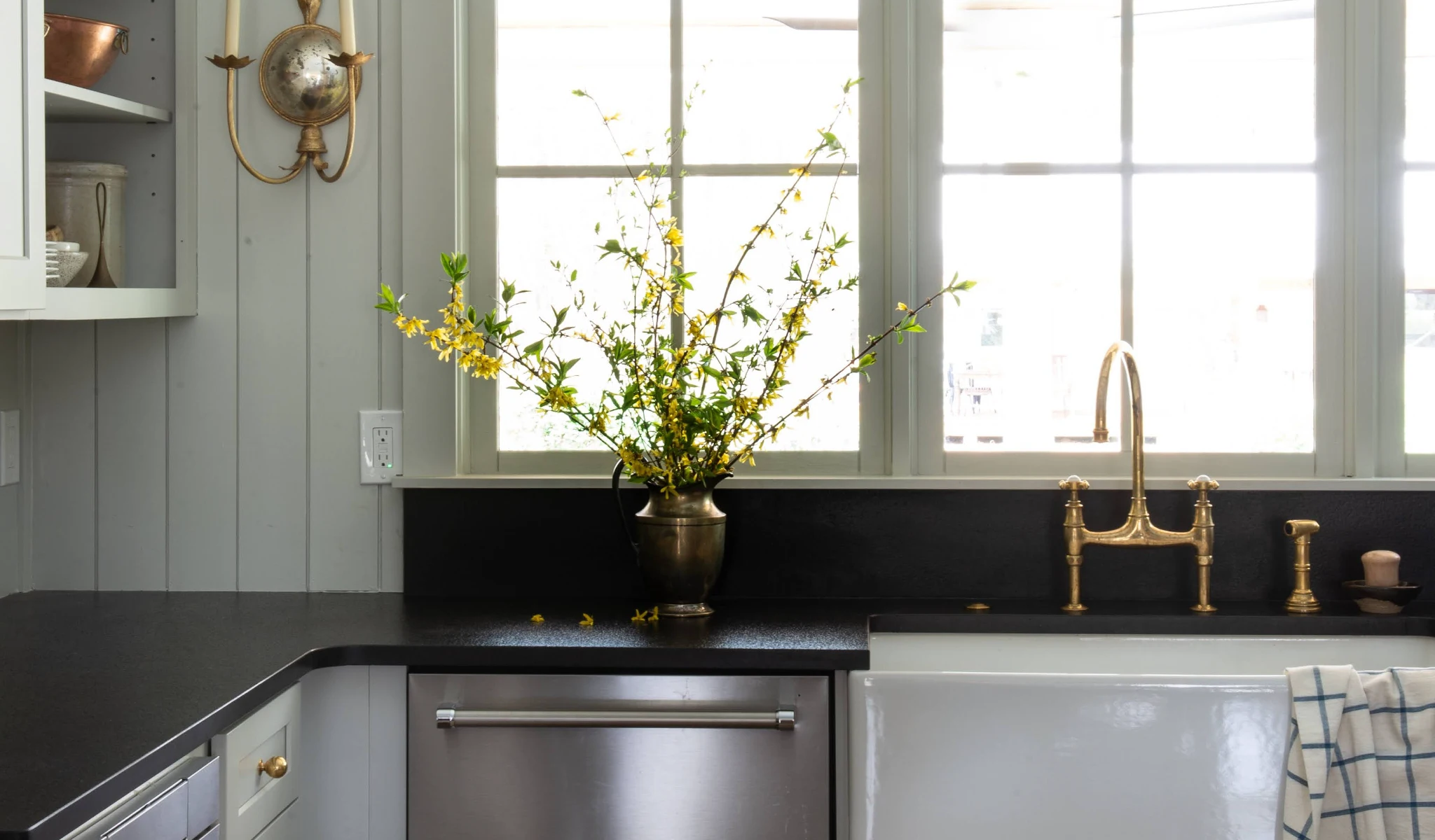 A kitchen with black countertops and a sink, built by home builders.
