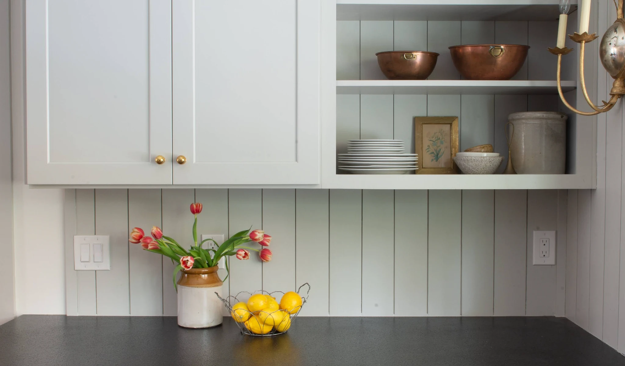 A kitchen with white cabinets and a vase of flowers in a new home construction.