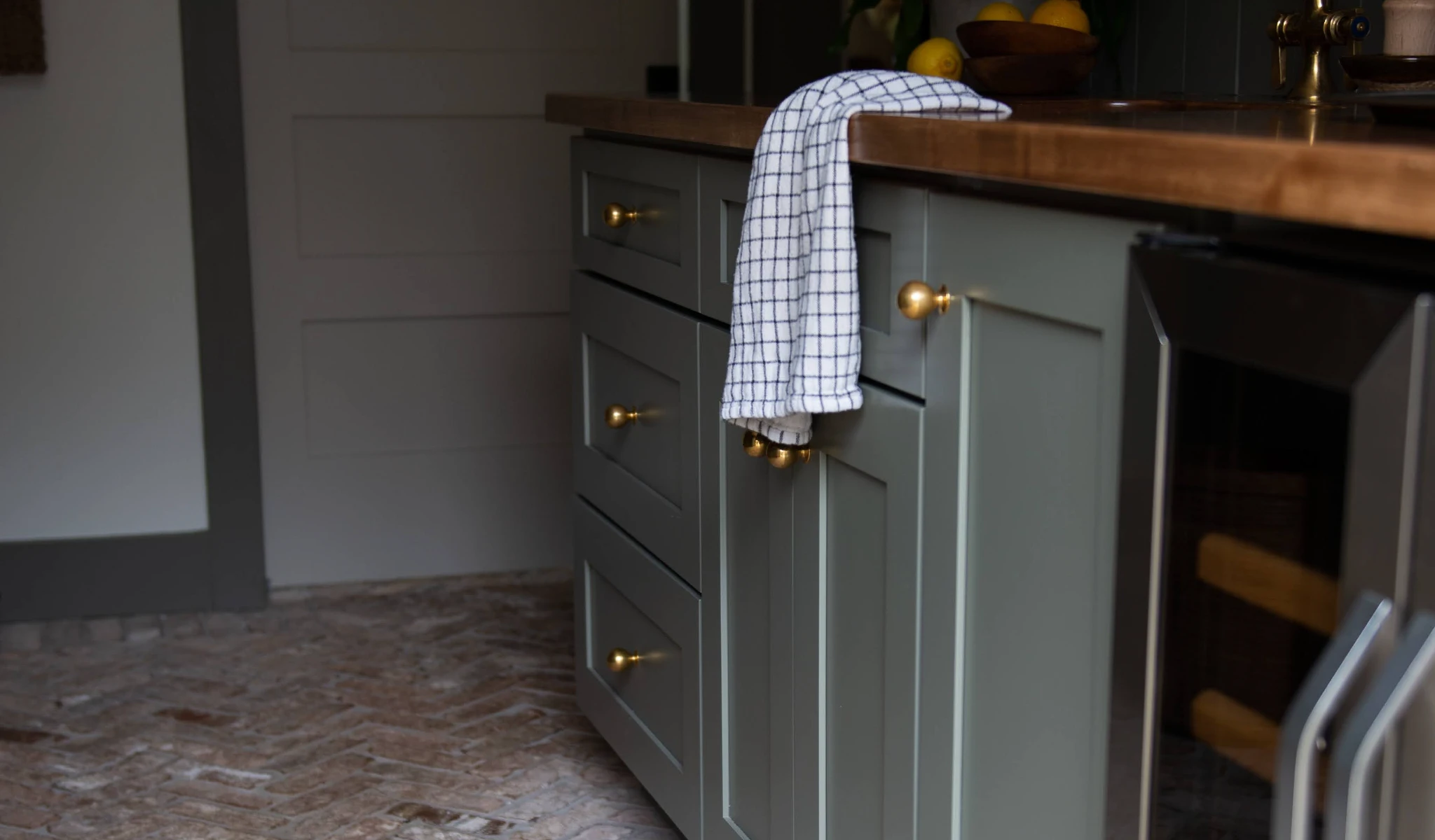 A kitchen with green cabinets and a towel on the counter.