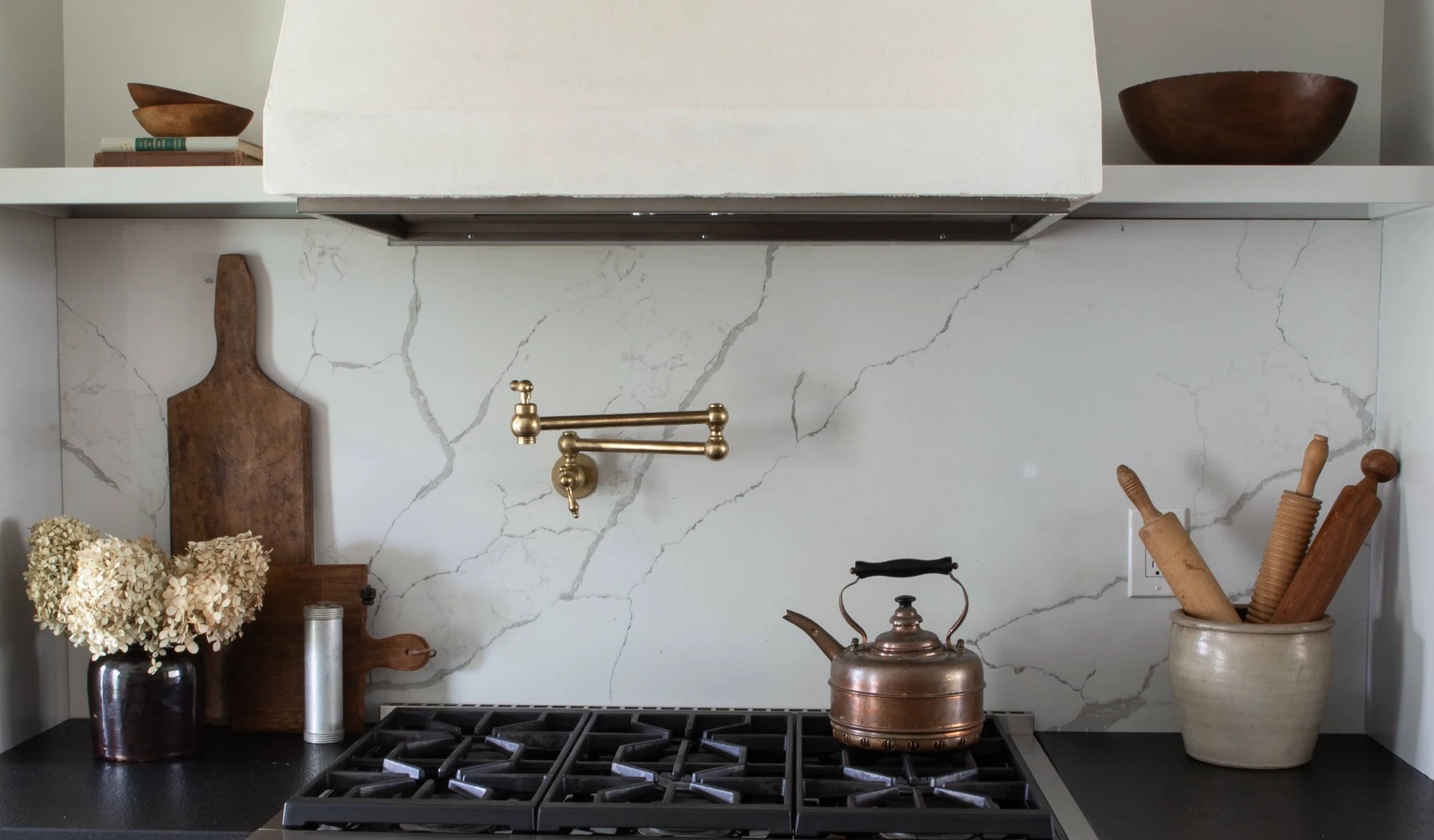 A kitchen with a stove, pots, and pans.