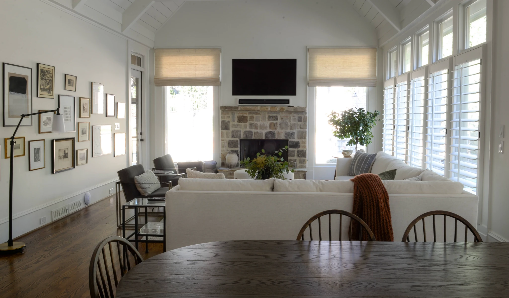 A white living room with a wooden table and chairs.