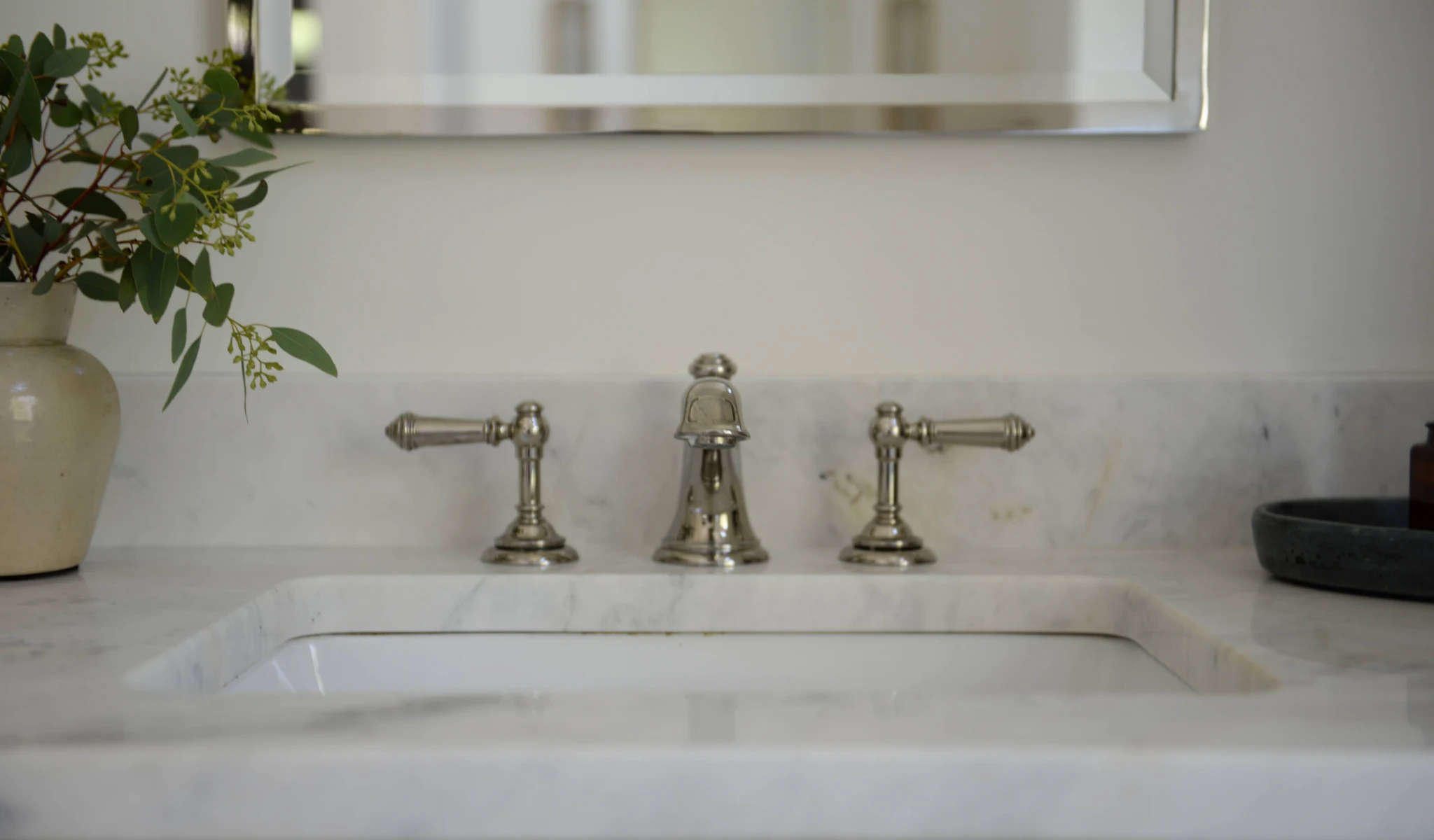 A newly constructed bathroom features a sleek white sink and mirror.