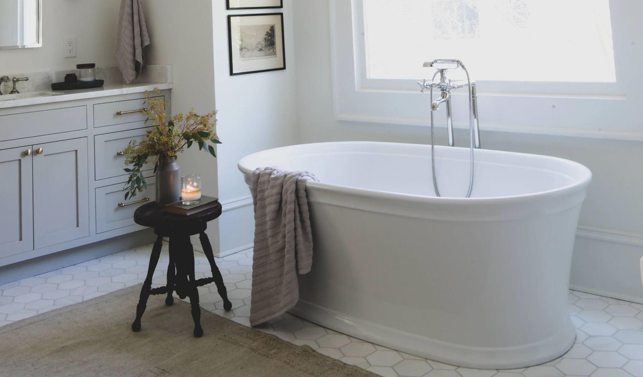 A white bathroom with a bathtub and sink, designed by a home designer.