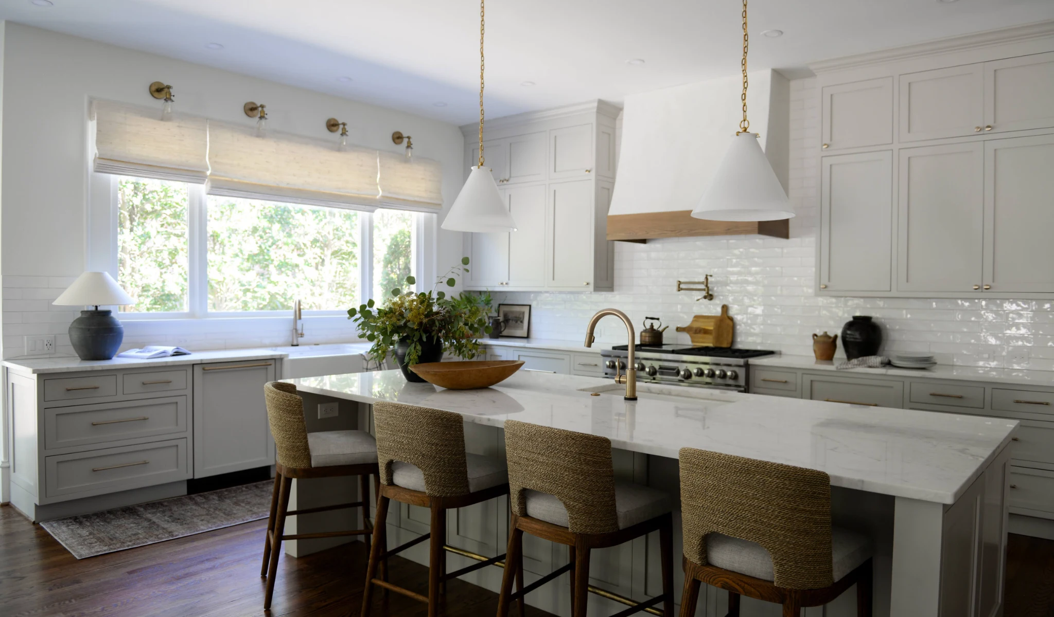 A white kitchen with a center island and bar stools.