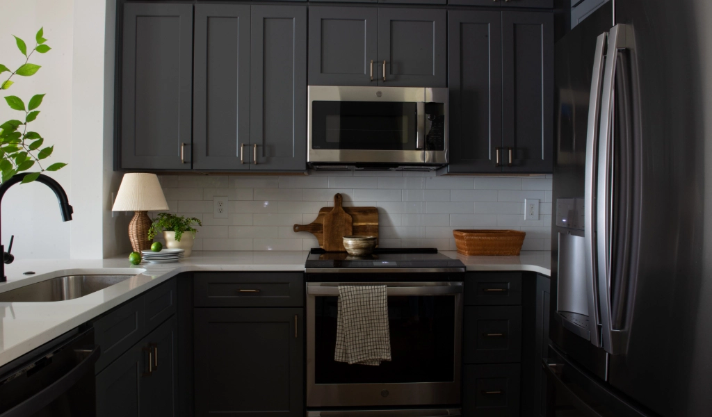A kitchen with black cabinets and stainless steel appliances.