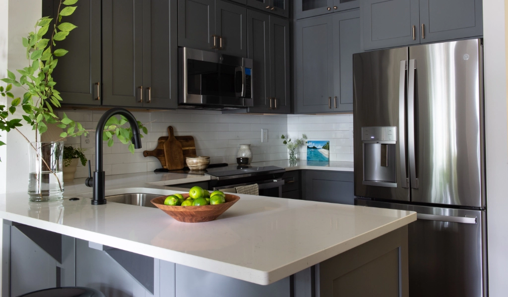 A kitchen with gray cabinets and stainless steel appliances.