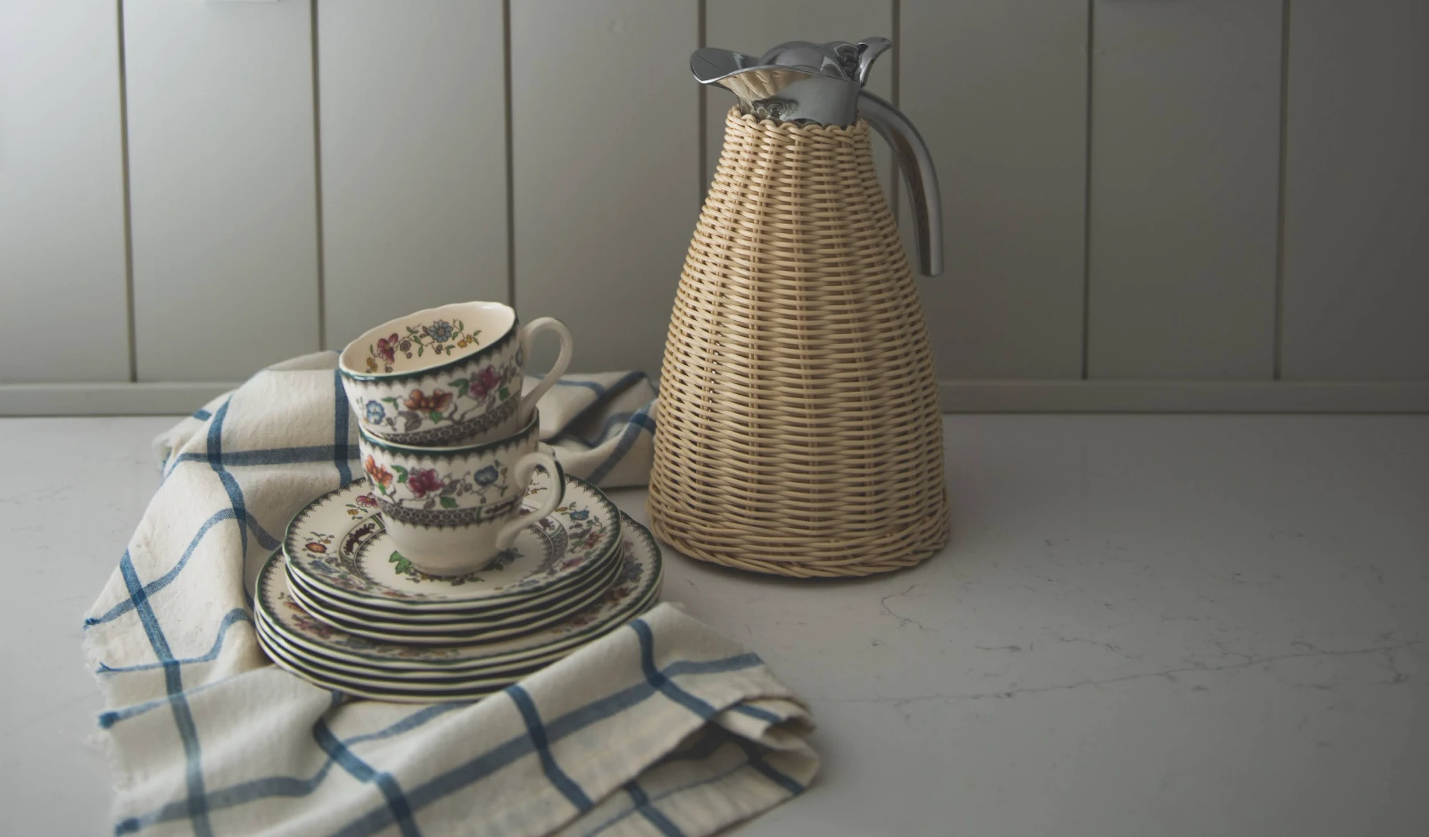 A wicker basket with a cup and saucer on a table, with a custom home builder's design touch.