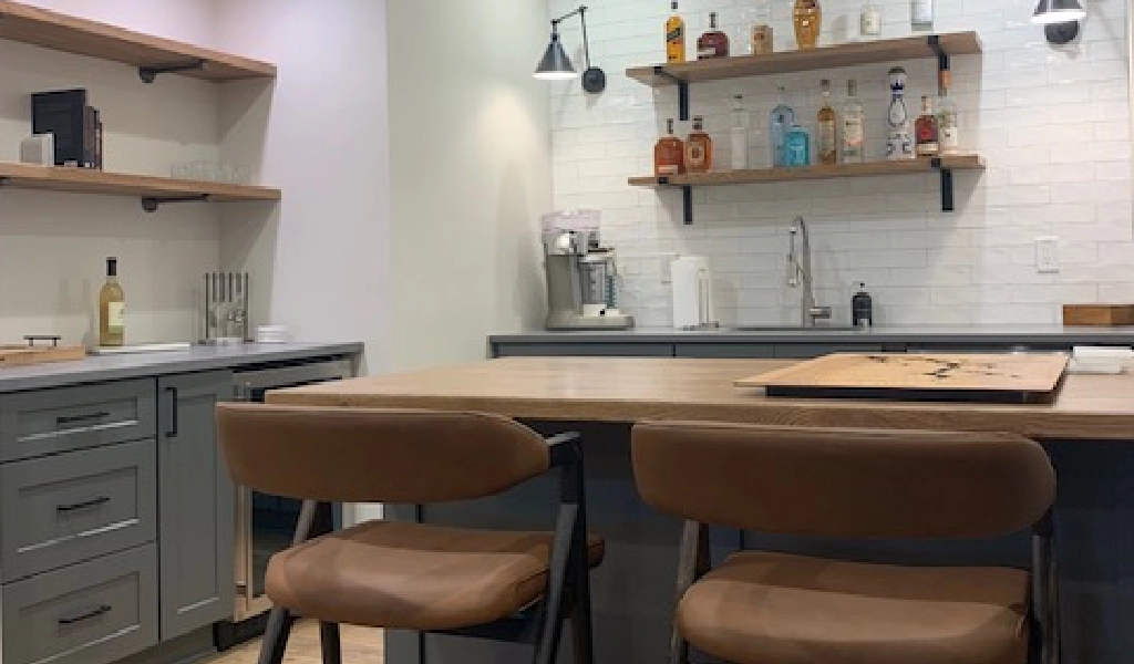 A kitchen with two stools and shelves.