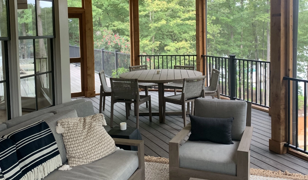 A screened-in porch with a table and chairs, perfect for enjoying the outdoors.