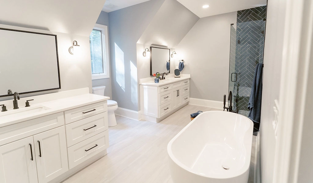 A white bathroom with a tub and sink designed by home builders.