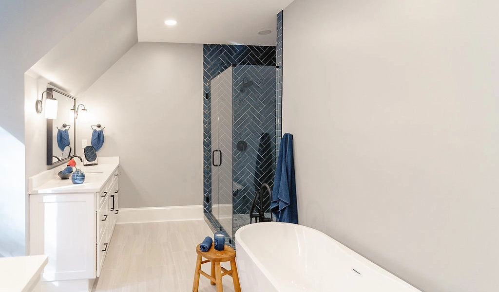A modern bathroom with a blue tiled shower.