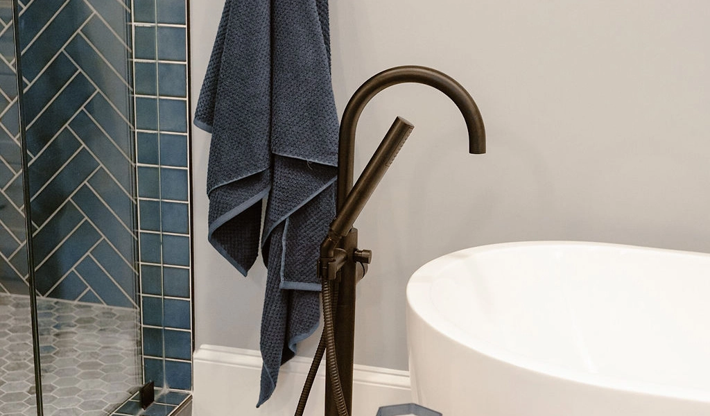 A bathroom with a bathtub and a towel hanging on the wall.