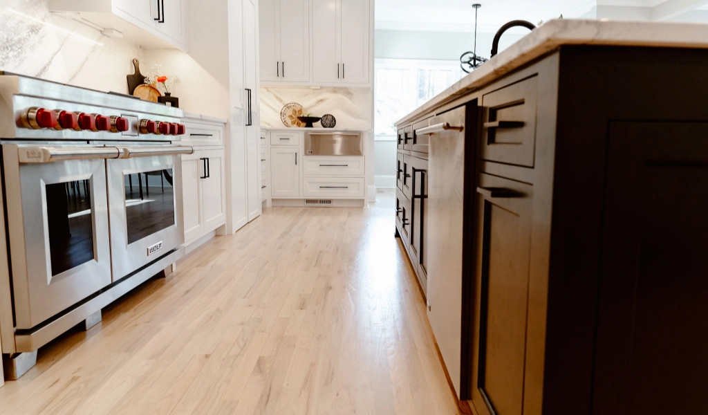 A kitchen with stainless steel appliances and hardwood floors.