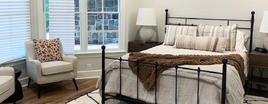 A bedroom with a bed and new chair.