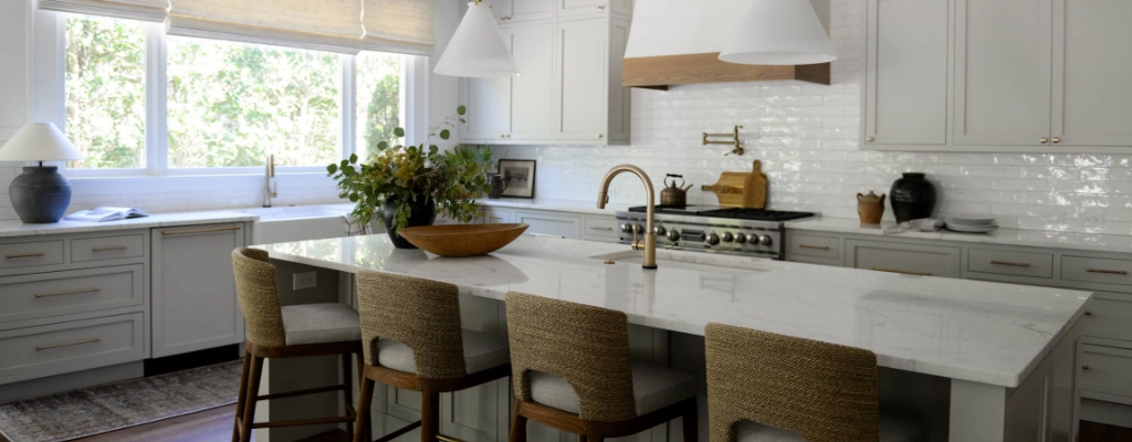 A white kitchen with a center island and stools.