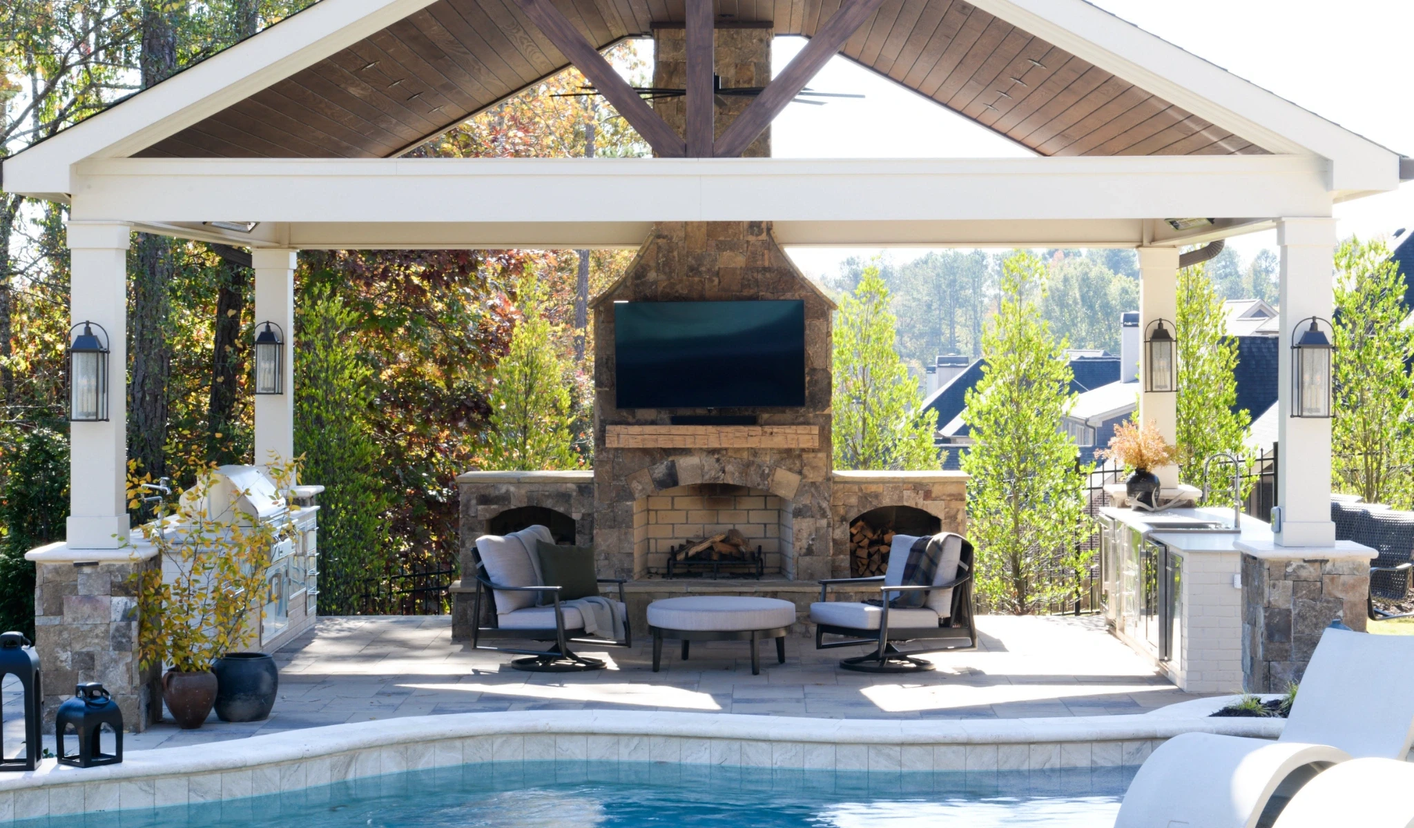 A stone patio with a fireplace and TV.