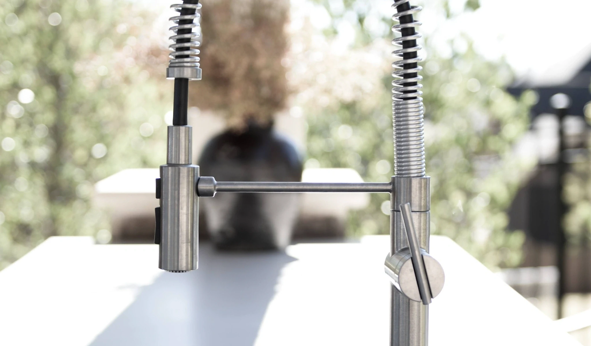 A stainless steel kitchen faucet outside.