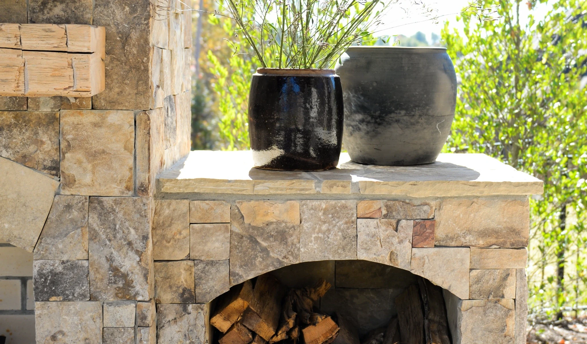A stone fireplace with two vases on top in a new home construction.