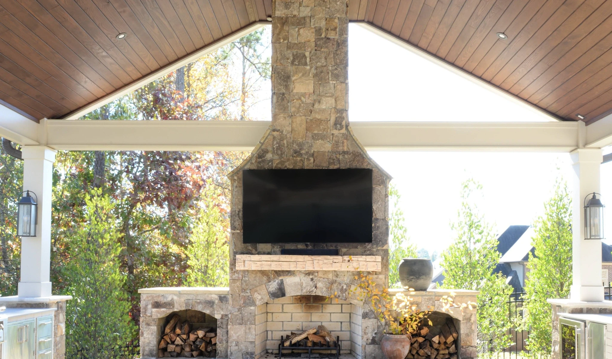 An outdoor fireplace with a flat screen TV.