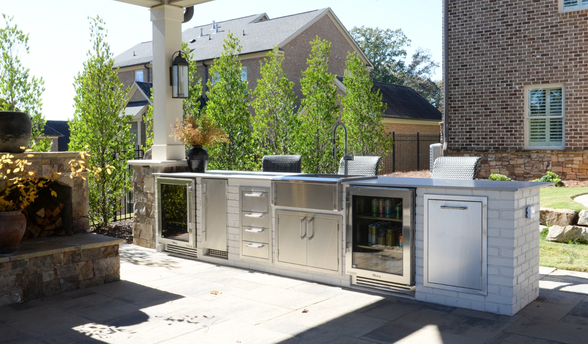 A new outdoor kitchen with stainless steel appliances and a fireplace.