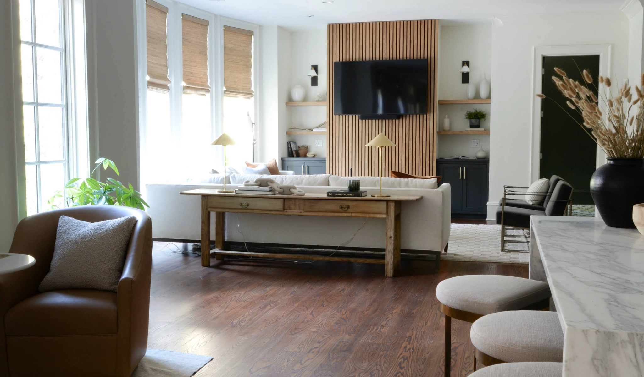 A living room with hardwood floors and a TV on the wall.