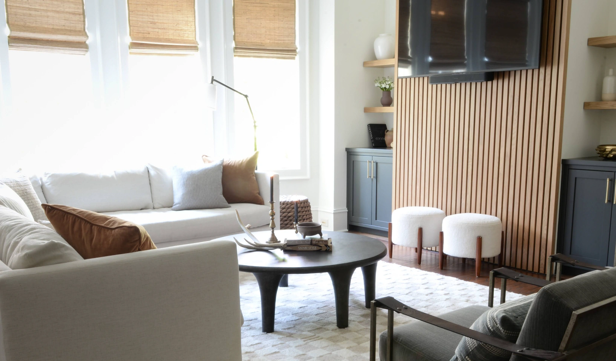 A living room with white furniture and a TV.