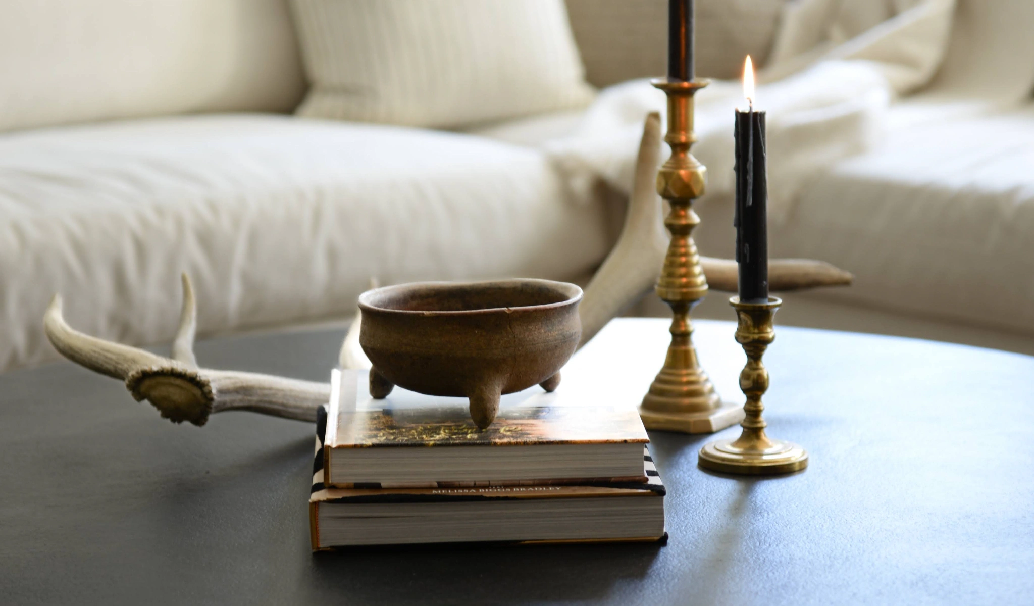 A coffee table adorned with new books and candles.