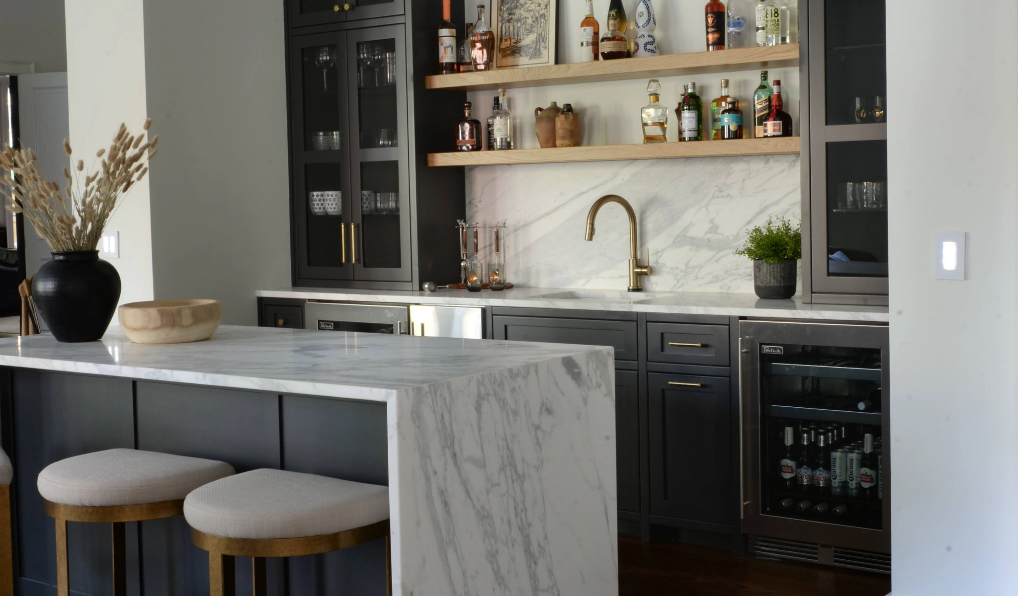 A black kitchen with a marble counter top, designed by a professional home renovator.