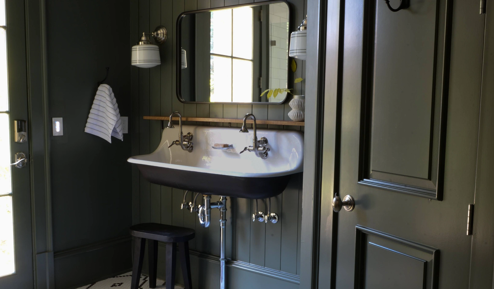 A bathroom with green walls and a sink.
