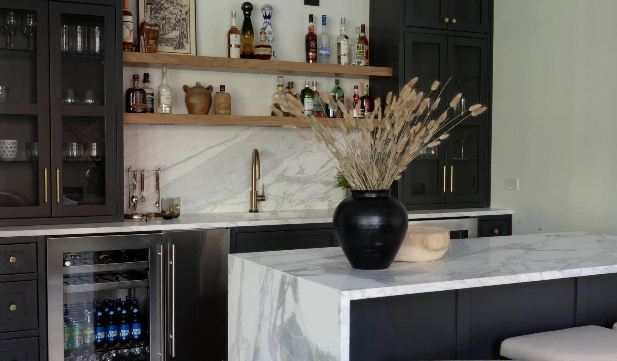 A kitchen with black cabinets and marble countertops, crafted by a custom home builder.