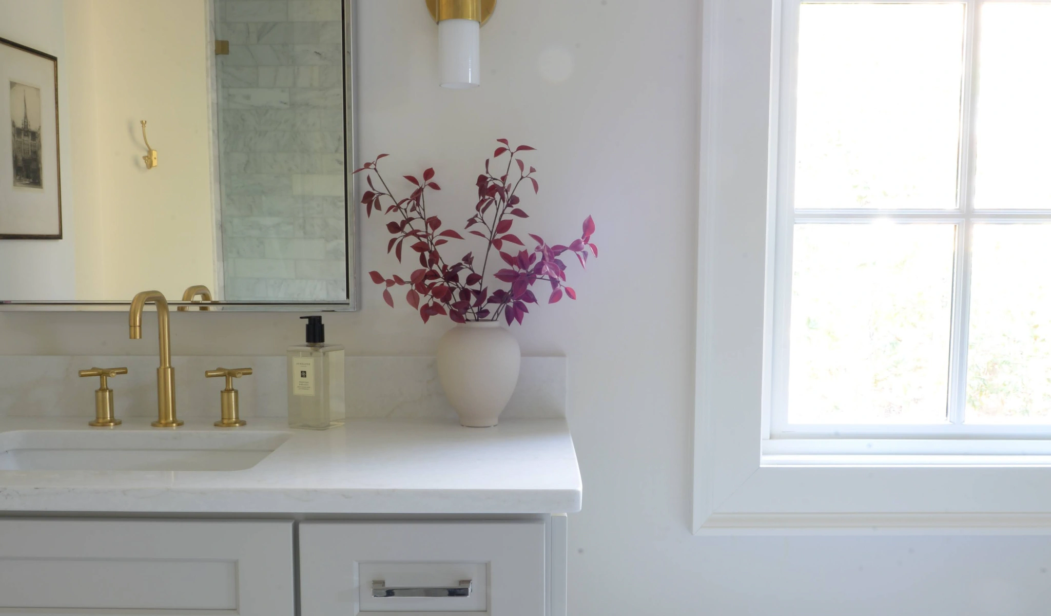 A bathroom with a white vanity and a window.