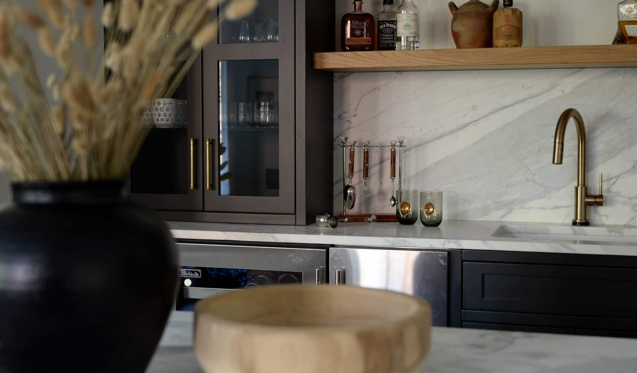 A black and white kitchen with a wooden bowl on the counter.