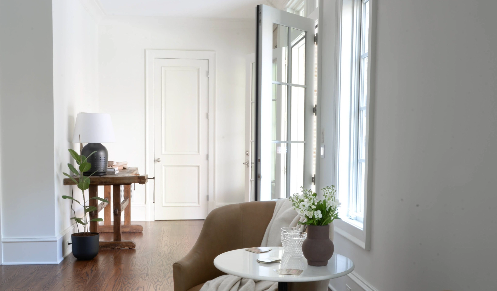 Entryway with white walls and wooden floors.