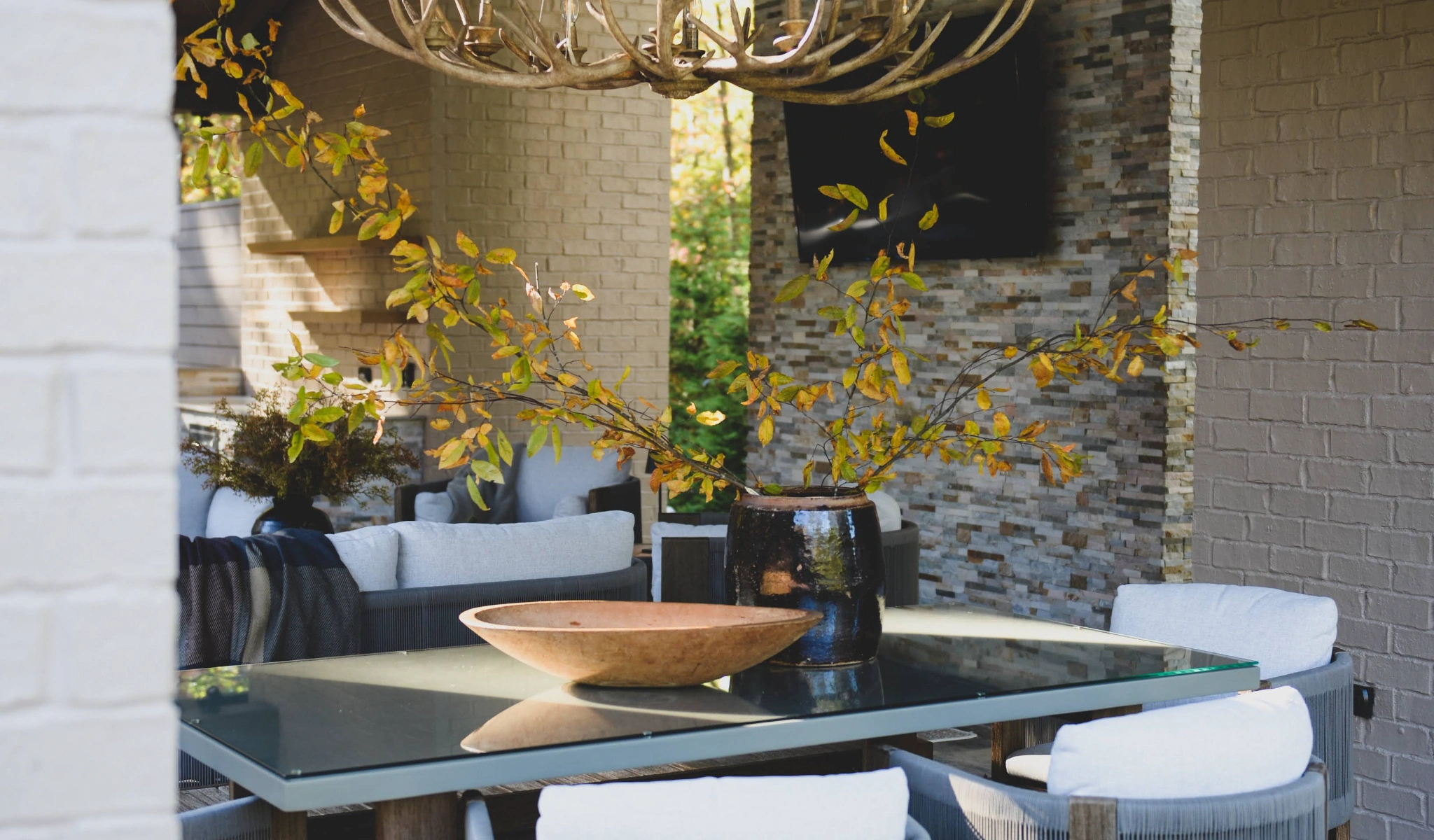 An outdoor dining area with a table and chairs designed by a home designer.
