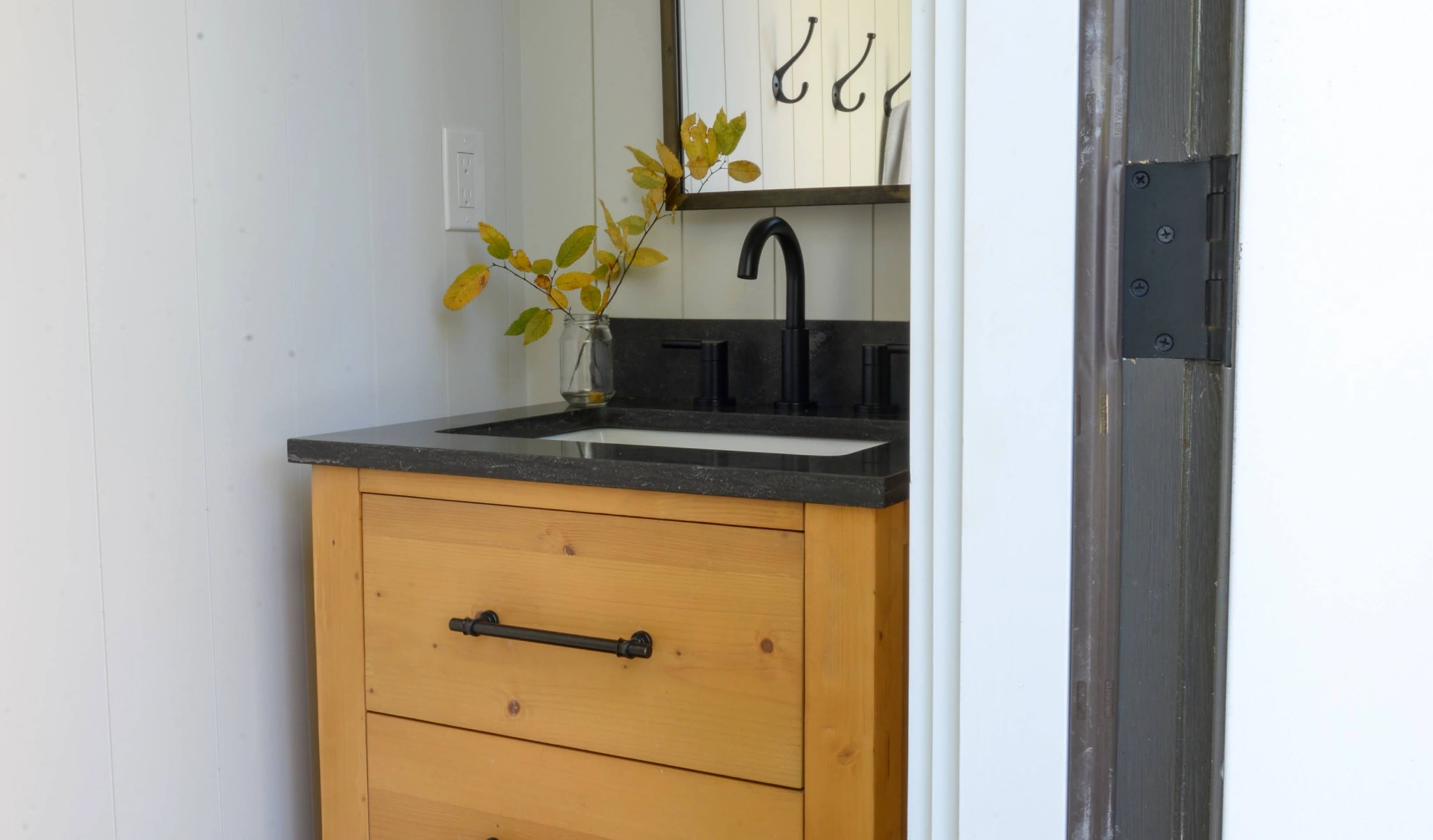 A small bathroom with a new sink and mirror.