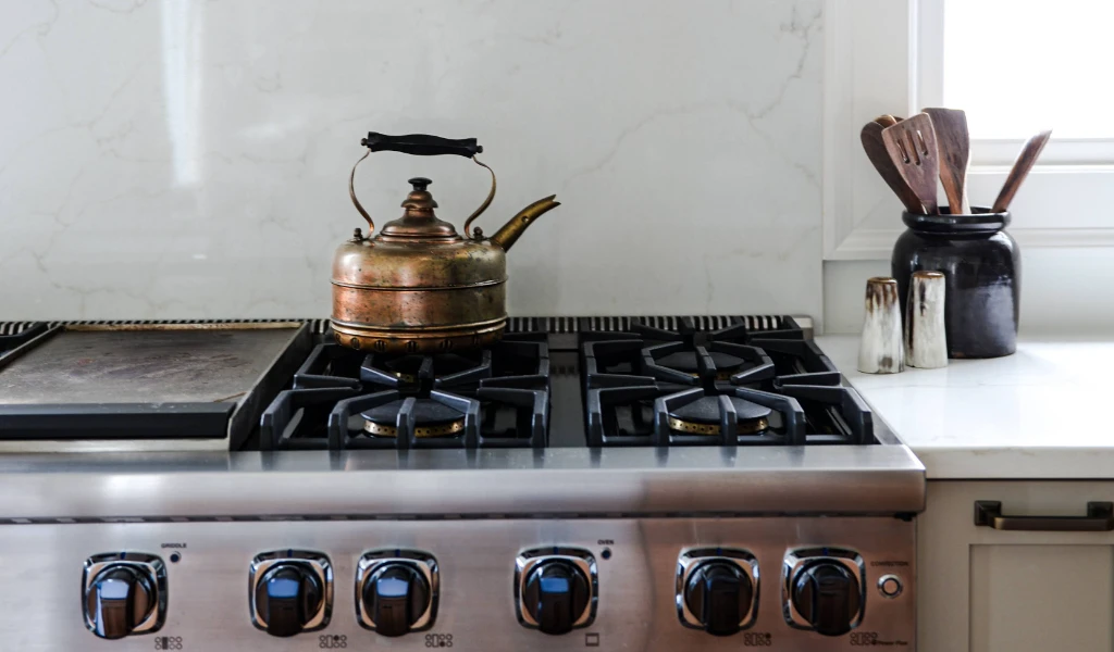 A stove top with a tea kettle on it.