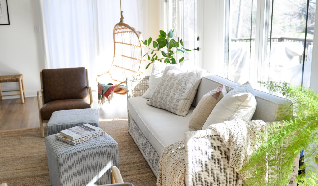 A living room with a white couch and plants.