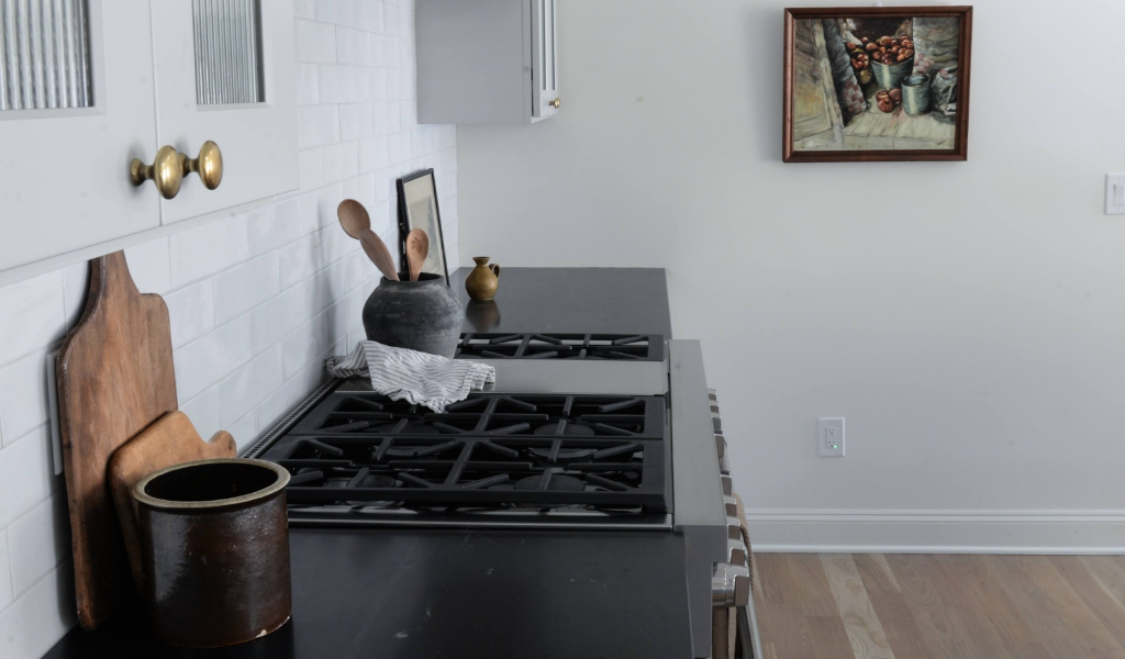 A black and white kitchen with a new stove top.