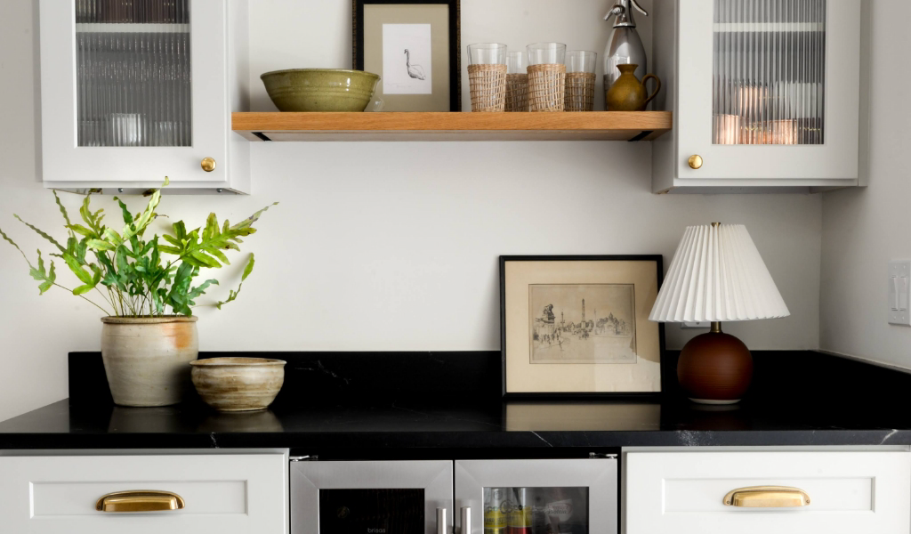 A white kitchen with black countertops and wooden shelves.