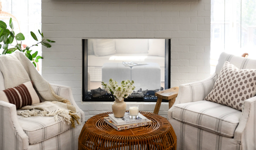 A living room with white furniture and a fireplace.
